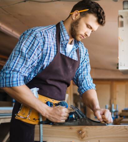 Man planing a board in workshop